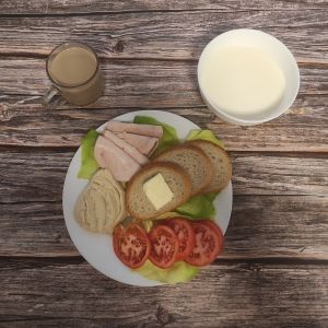 Zdjęcie przedstawia Dietę podstawową: Kawa zbożowa z mlekiem Zacierka na mleku Chleb mieszany pszenno-żytni Masło extra Pomidor Schab Kruchy z Liszek Sałata zielona Hummus